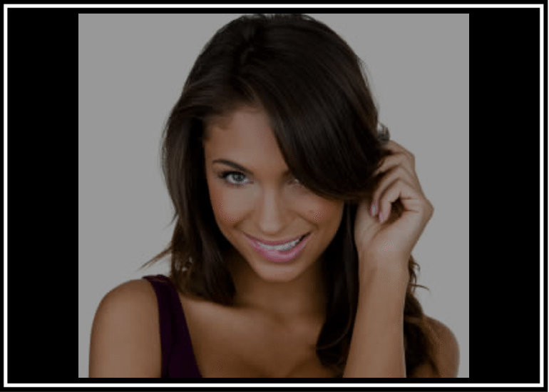 Smiling young woman with long dark hair and blue eyes.