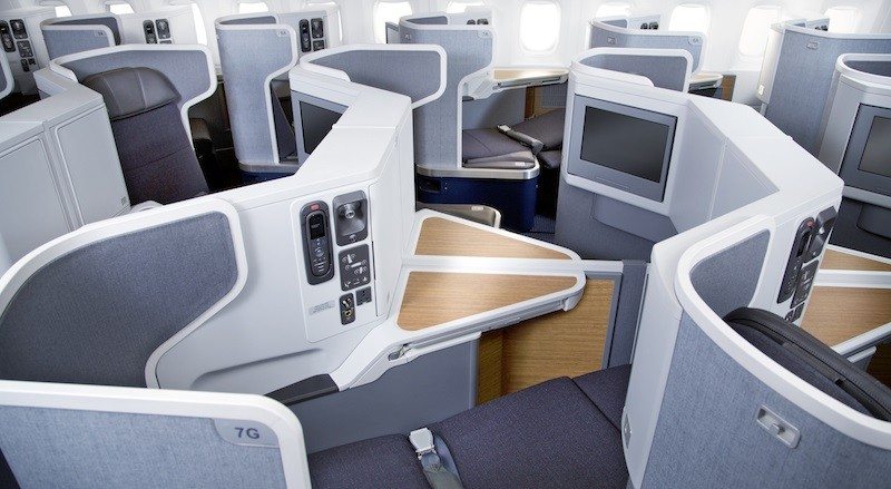 Luxurious business class airplane seats with ample legroom and privacy.